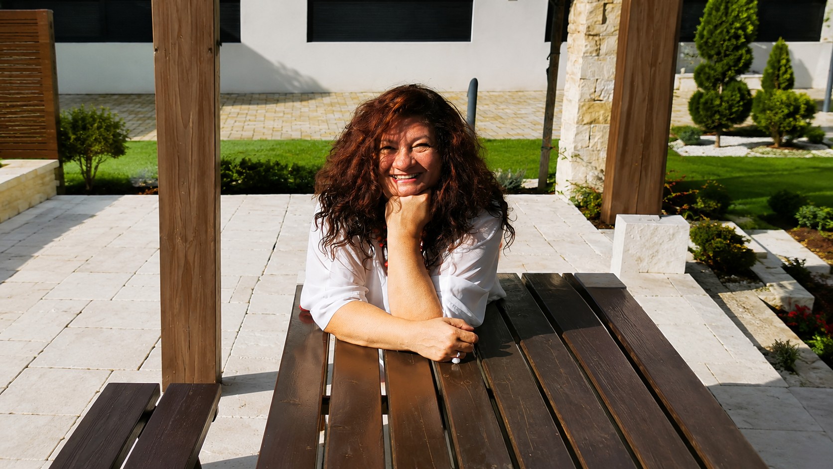 Heike Schertz lachend an einem Holztisch